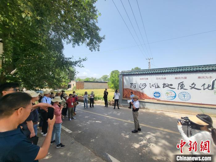 圖為中國地質(zhì)大學(北京)教授張緒教介紹村落情況?！『衍?攝