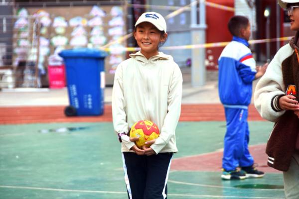 在高原上教孩子們打手球，“慢慢兒來，甭著急！”