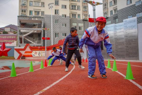 在高原上教孩子們打手球，“慢慢兒來，甭著急！”