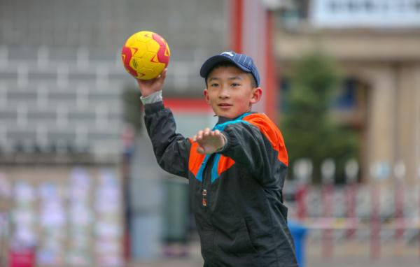 在高原上教孩子們打手球，“慢慢兒來，甭著急！”