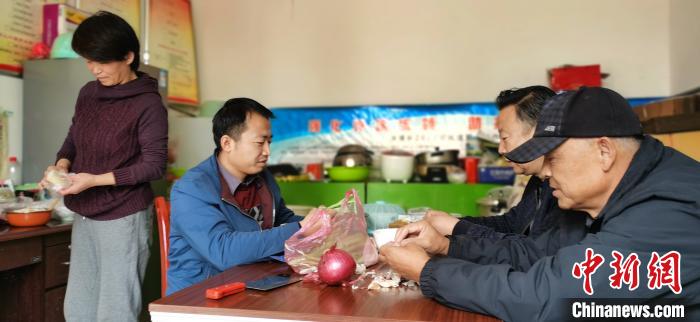 圖為扶貧路上“臨時(shí)一家人”準(zhǔn)備午餐?！∥航ㄜ?攝