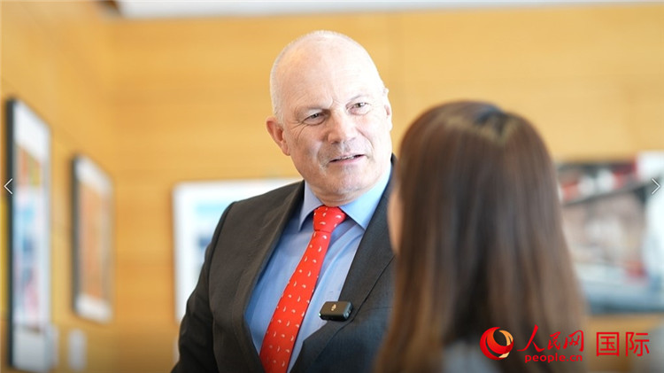 瑞士駐華大使白瑞誼介紹使館內(nèi)陳列的照片。人民網(wǎng) 彭昱凱攝