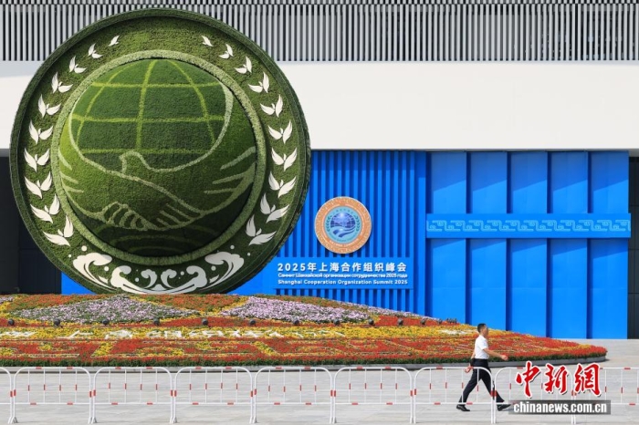 8月31日，天津，一名工作人員從2025年上海合作組織峰會主會場外的景觀花壇旁經(jīng)過。當(dāng)日，2025年上海合作組織峰會在天津舉行。<a target='_blank' href='/'><p  align=