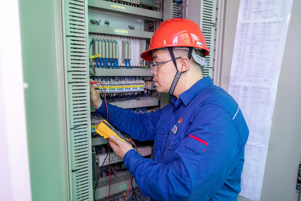 呂曉勇在保護盤柜前檢查二次回路接線情況。受訪者供圖