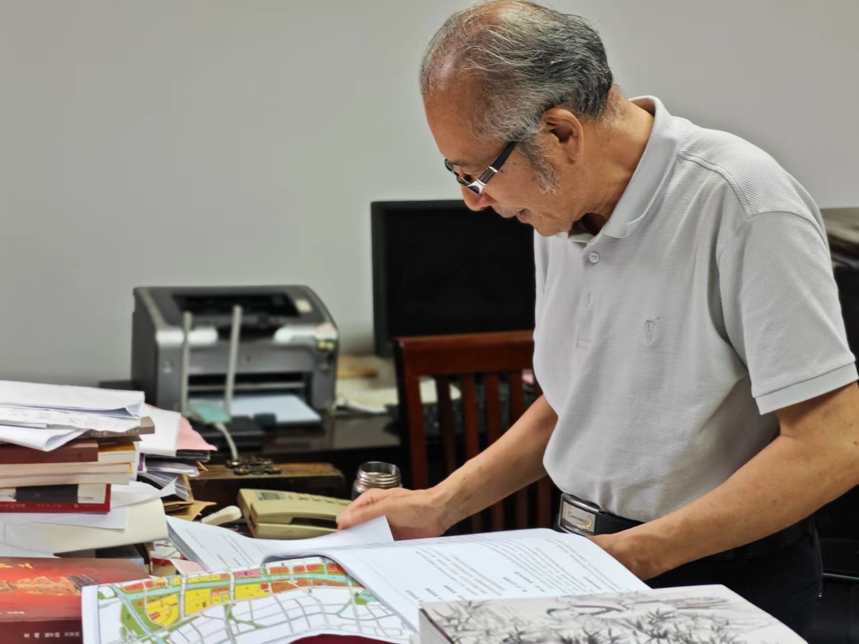 顧風(fēng)在辦公室翻閱資料。人民網(wǎng)記者 黃鈺攝