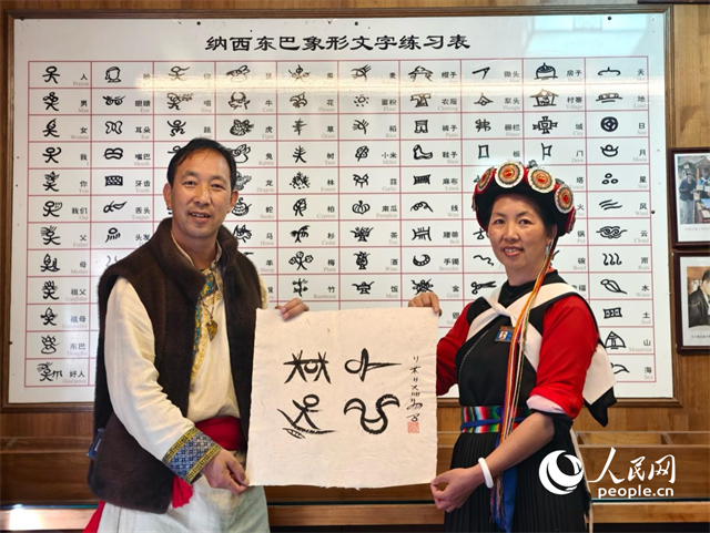 人民網(wǎng)“行進中國”云南調(diào)研采訪團走進麗江，和閏元現(xiàn)場用東巴文寫下“行進中國”。人民網(wǎng)記者 符皓攝