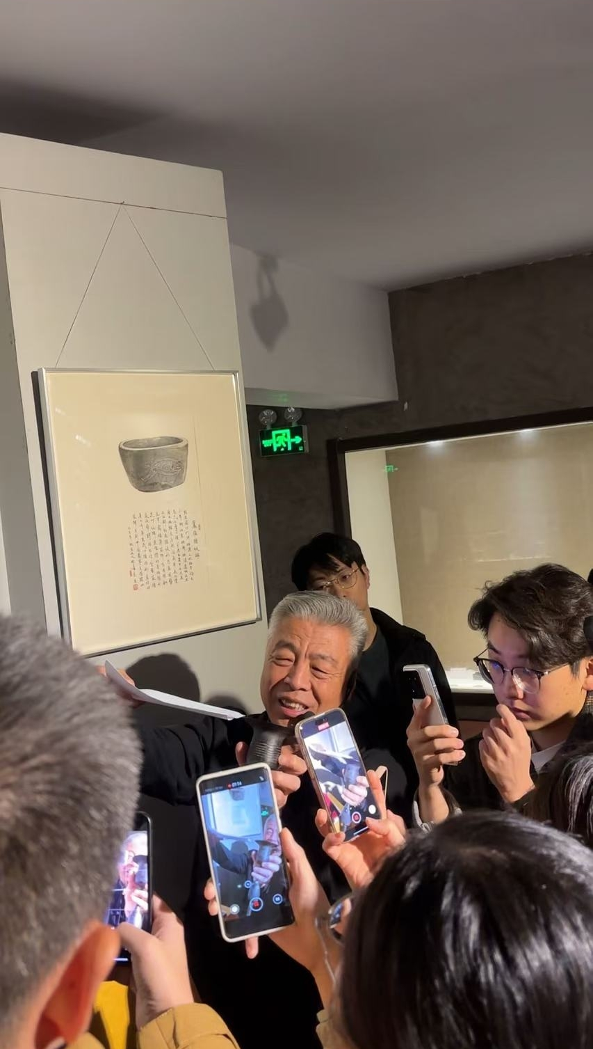 黑陶邢文化博物館館長邢葆東展示兩張相疊的A4紙，向記者解釋此為杯口的厚度。