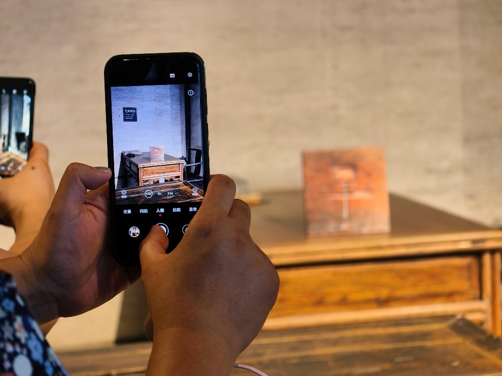 2025年7月15日，暑期研學(xué)團(tuán)小朋友在浙江省紹興市三味書屋拍攝魯迅讀書座位及課桌上的“早”字。受訪者供圖