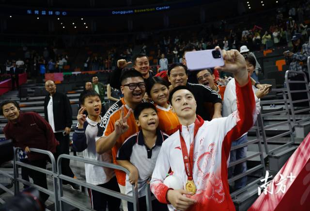 11月12日，十五運(yùn)會男籃成年組決賽，廣東隊獲得冠軍后，胡明軒與球迷們合影留念。張由瓊 攝