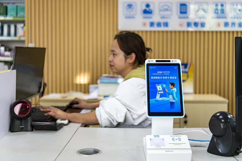 2024年4月10日，浙江金華市區(qū)一家民眾大藥房柜臺(tái)上設(shè)置著醫(yī)?！八⒛樦Ц丁睓C(jī)器，群眾看病更加便利。