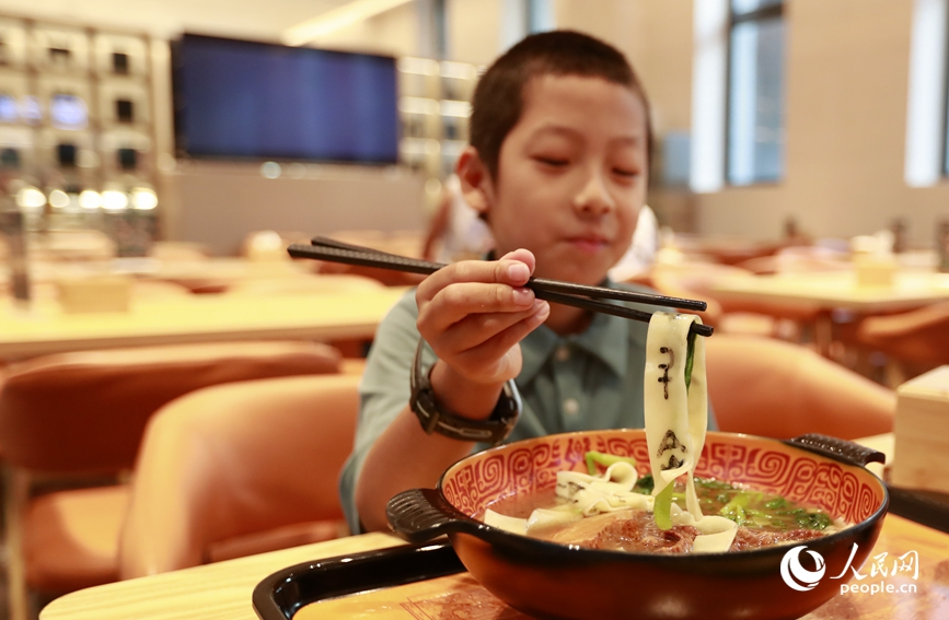 殷墟博物館推出的甲骨文面深受游客喜愛。人民網(wǎng)記者 慎志遠(yuǎn) 攝