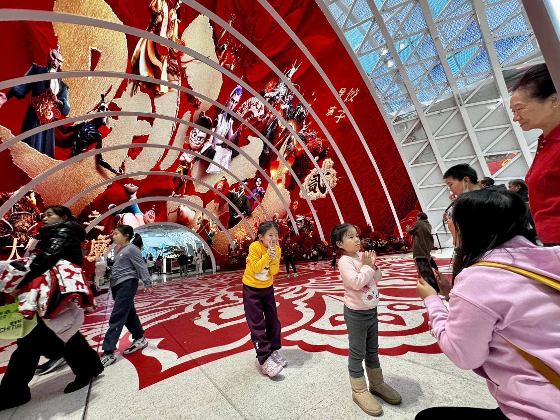 乙巳蛇年春節(jié)期間，影迷在《哪吒之魔童鬧?！肪薹?bào)前拍照打卡。