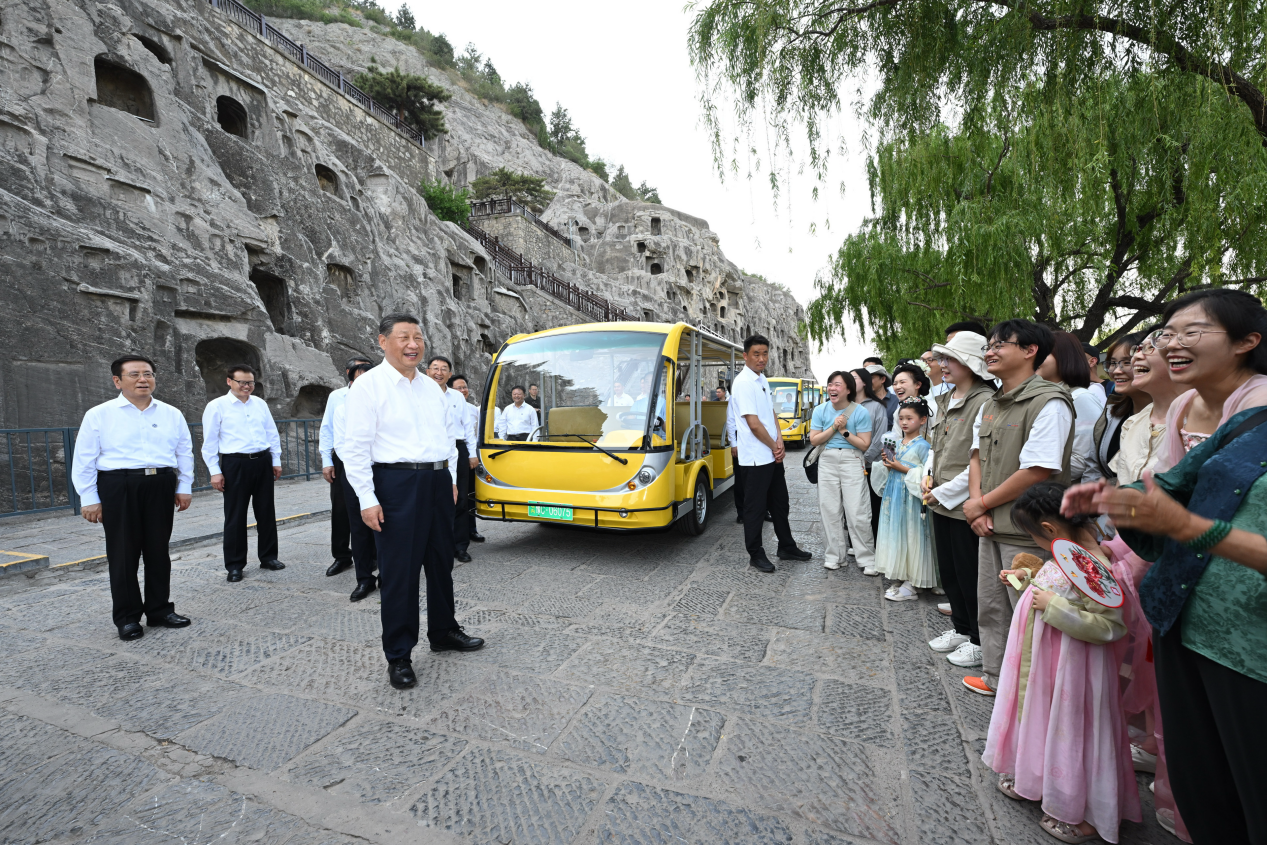 5月19日，習近平在洛陽龍門石窟考察時，同游客親切交流。