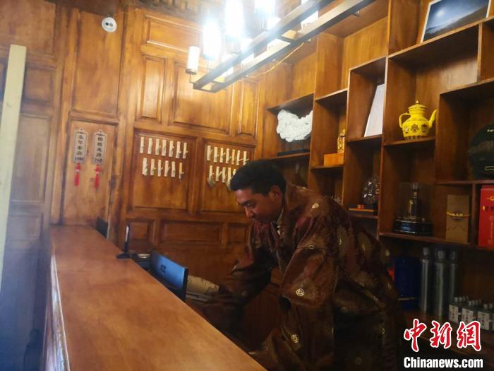 圖為桑杰才讓用電腦處理財(cái)務(wù)?！∈缝o靜 攝