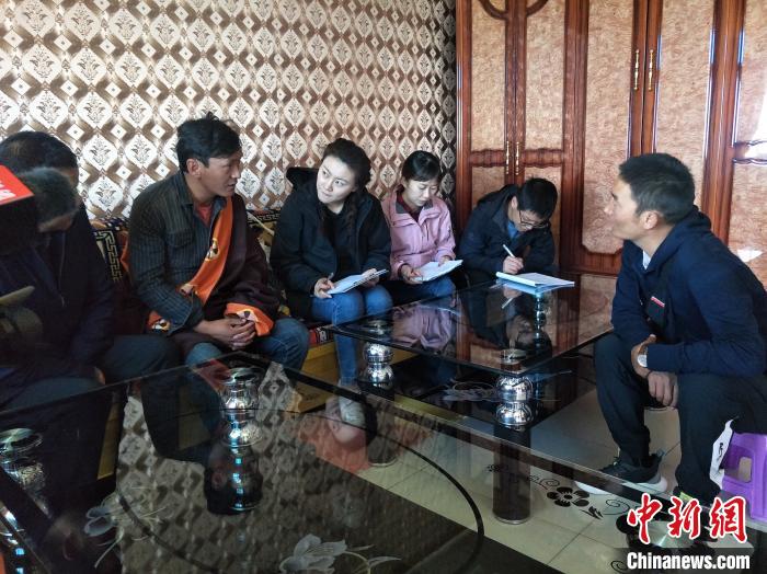 圖為調(diào)查組工作人員正在入戶調(diào)查?！∑钤鲚?攝