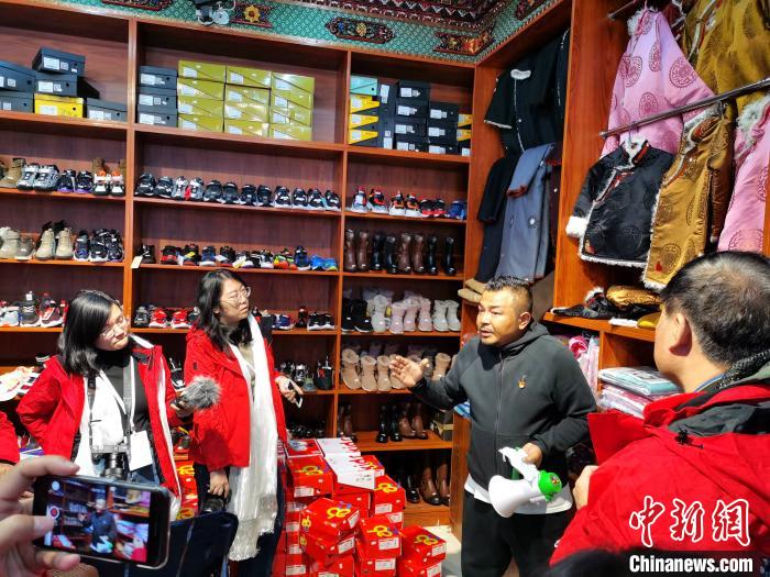 圖為中外媒體在玉樹州玉樹市甘達(dá)村采訪?！?zhí)砀?攝