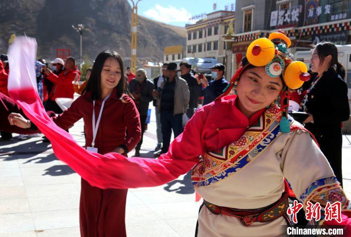 圖為中外記者向當(dāng)?shù)孛癖妼W(xué)習(xí)民族歌舞文化?！?zhí)砀?攝