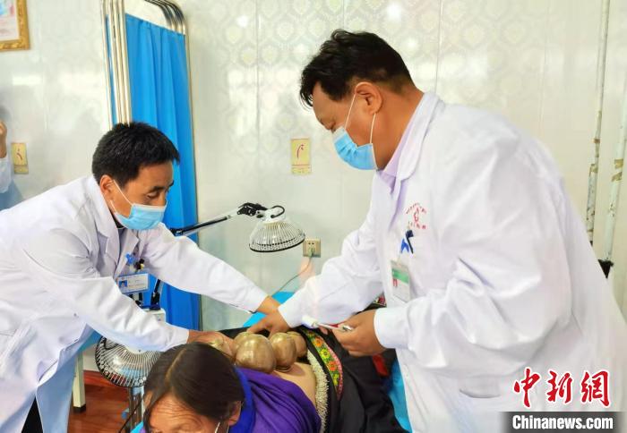 圖為看照加手把手帶徒弟加老(左一)進(jìn)行拔罐療法?！堟?攝