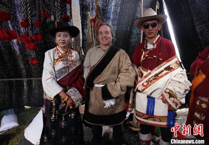 圖為一名外籍攝影師(中)身穿藏服和藏族民眾合影留念。　馬銘言 攝