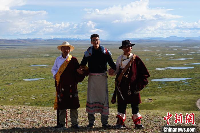 圖為一名留學生身穿自己國家的服飾和藏族民眾合影留念?！●R銘言 攝