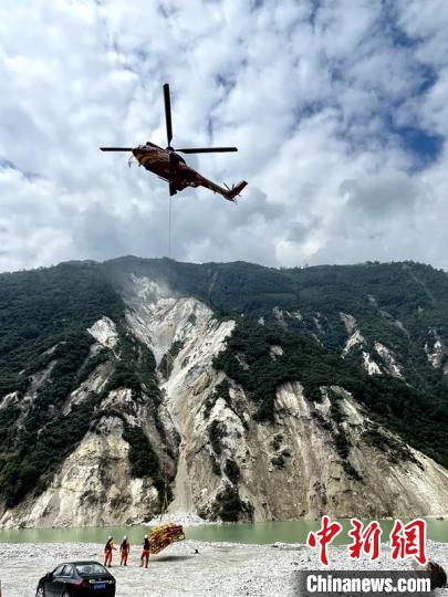 直升機正在運輸110千伏唐下線應(yīng)急塔塔材。　衛(wèi)科 攝