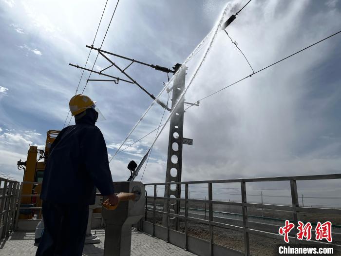 圖為高壓水槍的水柱沖洗絕緣子串?！「邌⒑?攝