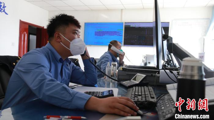 圖為貨運(yùn)調(diào)度人員與外勤工作人員聯(lián)系掌握車輛裝載情況?！±钌?攝