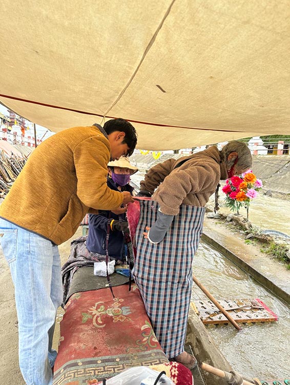 扎西奪爾登為路邊老人送去保暖圍腰。阿壩州文明辦供圖