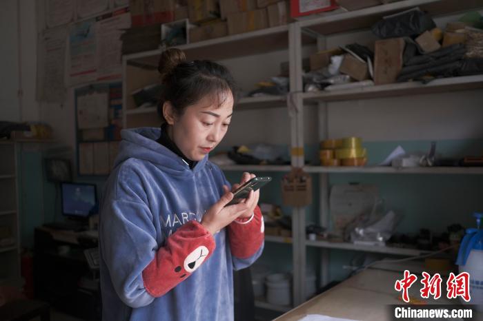 正在快遞站點(diǎn)內(nèi)忙碌的楊莉春?！『闻罾?攝