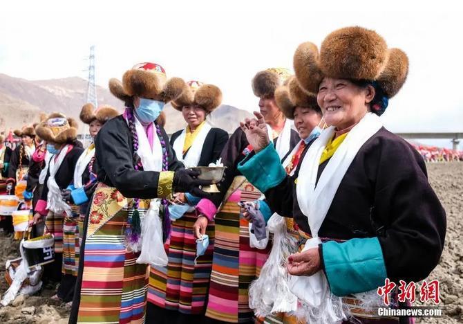 資料圖：西藏自治區(qū)拉薩市曲水縣才納鄉(xiāng)協(xié)榮村參加春耕儀式的村民互敬青稞酒。按照傳統(tǒng)，當?shù)卮迕裆碇?jié)日盛裝，舉行隆重的儀式，祈福一年的豐收。<a target='_blank' ><p  align=