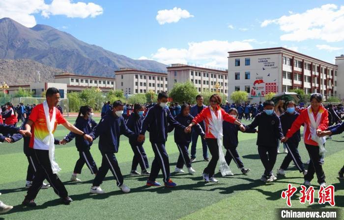 圖為世界冠軍與拉薩阿里地區(qū)高級中學(xué)學(xué)生一起跳鍋莊。　冉文娟 攝