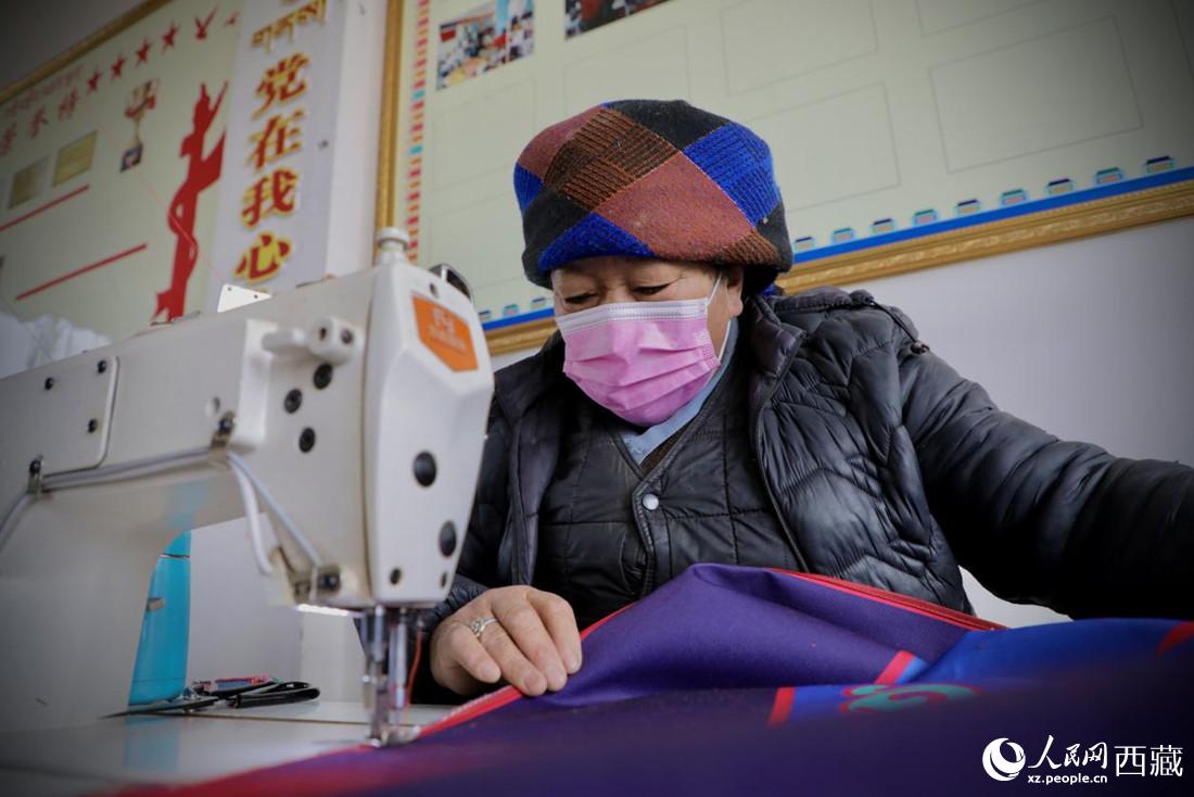 農(nóng)牧民專業(yè)合作社里的村民正在制作門簾。人民網(wǎng) 次仁羅布攝