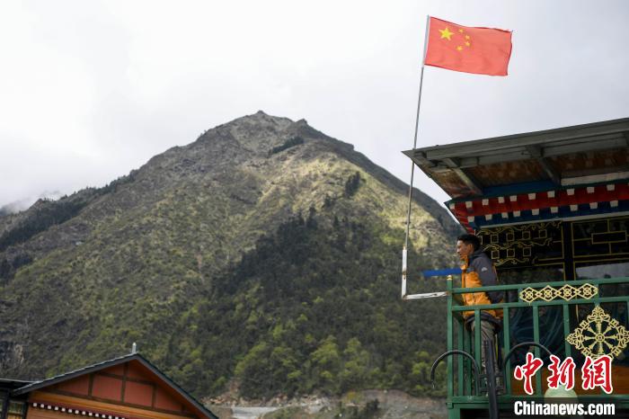 村民站在樓房上觀望?！钊A峰 攝