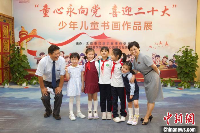 圖為與會(huì)嘉賓與入選畫作的“小作者”們?cè)谡褂[上合影?！≈袊貙W(xué)研究中心供圖