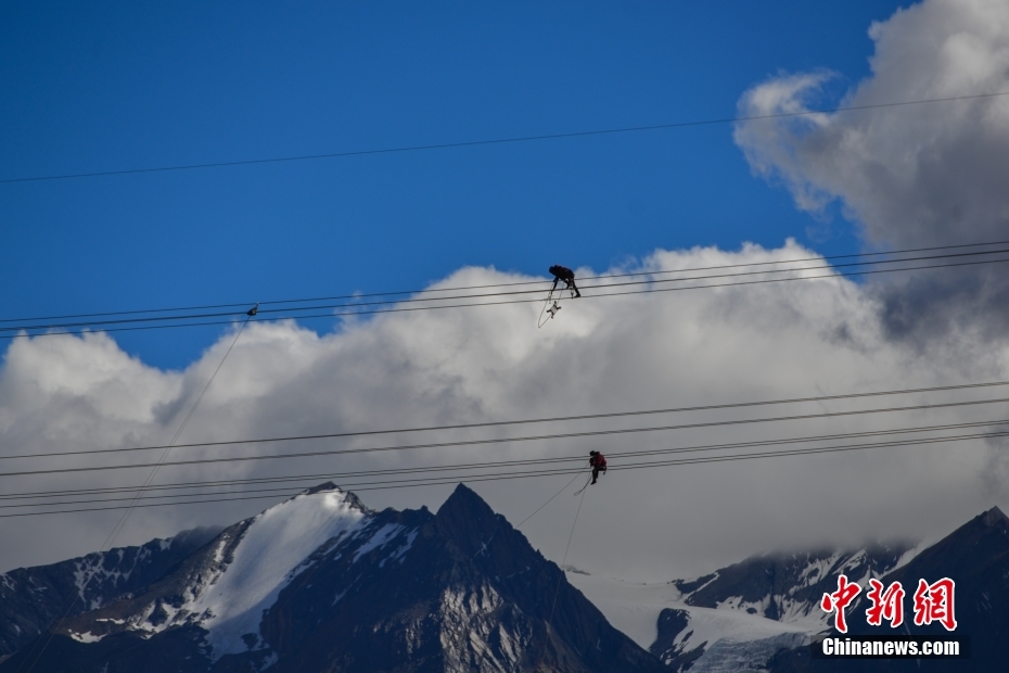 資料圖為2020年6月23日，西藏阿里聯(lián)網(wǎng)工程施工人員在日喀則希夏邦馬雪山附近進(jìn)行走線作業(yè)，安裝絕緣設(shè)備。 <a target='_blank' href='/'><p  align=