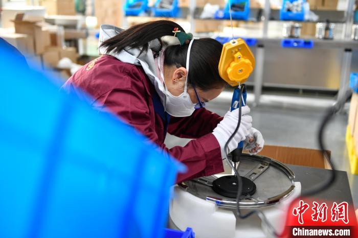 圖為工人正在組裝炊具?！∝暩聛硭?攝