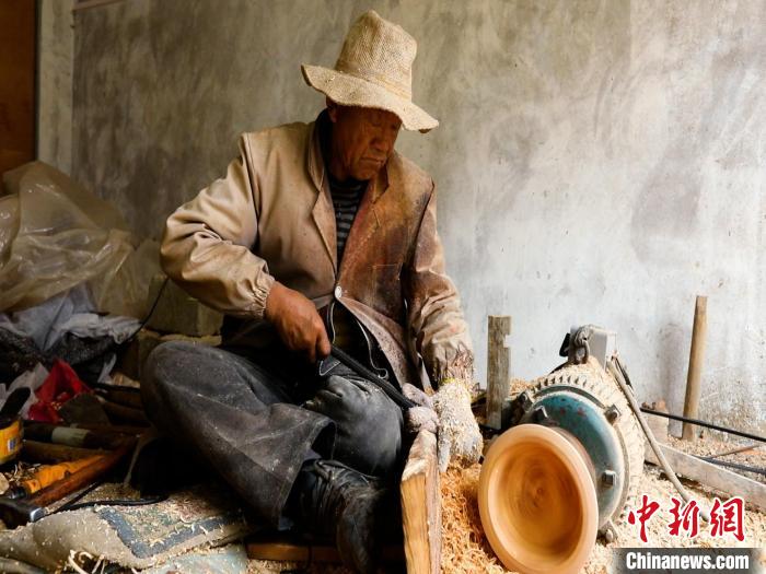 圖為手工藝人正在制作木碗。　 鄧海平 攝