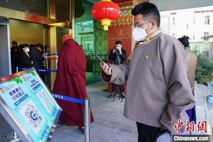 圖為政協(xié)委員掃場(chǎng)所碼進(jìn)入會(huì)場(chǎng)?！〗w波 攝