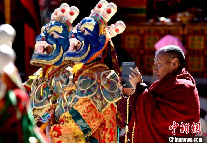 2月19日，正在拍攝跳神活動的僧人。　李林 攝