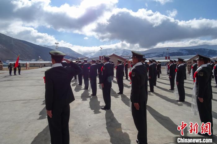 雪山下，退役士兵向軍旗敬軍禮。　李學(xué)文 攝