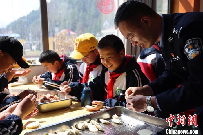 圖為亞東邊檢站民警與駐地小學生其樂融融包餃子?！『?攝