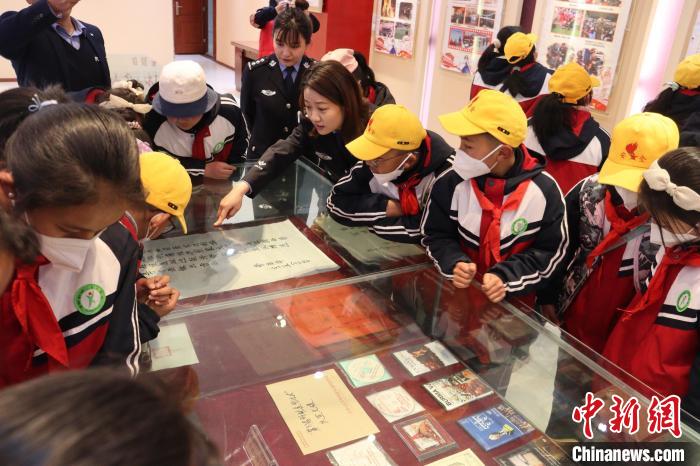 圖為亞東邊檢站民警為駐地小學生講解該站榮譽發(fā)展史。　胡利媛 攝