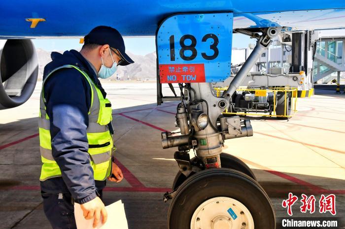 圖為機(jī)場(chǎng)工作人員進(jìn)行相關(guān)檢查?！≈芎?攝