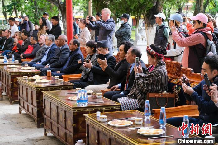 5月19日，中外嘉賓在羅布林卡和游客一起觀看藏戲?！〗w波 攝