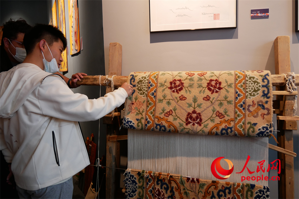 觀眾正在觀賞展出的藏毯。人民網(wǎng) 韋衍行攝