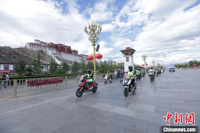 圖為比賽選手途經(jīng)布達拉宮?！∮文恋厍蚬﹫D