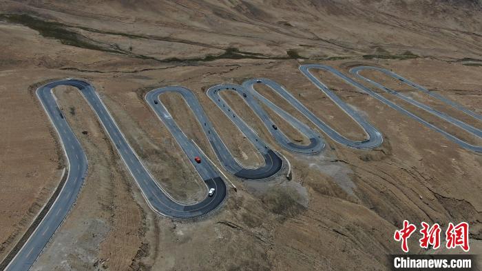 圖為騎手前往珠峰大本營途經(jīng)108道拐?！∮文恋厍蚬﹫D