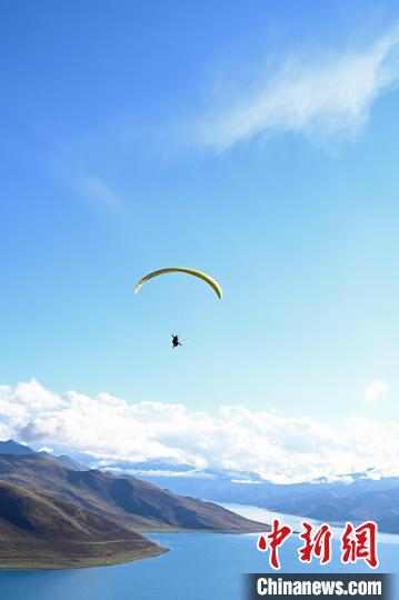圖為在羊卓雍錯(cuò)，游客體驗(yàn)高空滑翔。　趙朗 攝