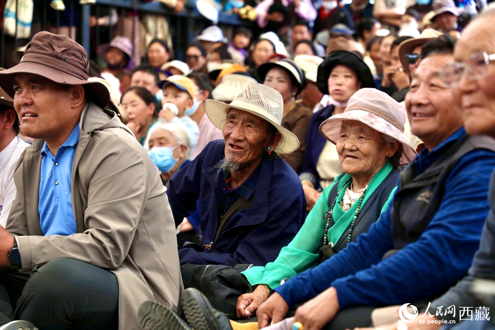 當(dāng)?shù)厝罕姾陀慰陀^看藏戲演出。