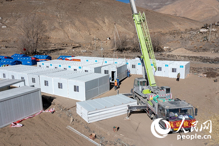 1月9日，在日喀則市定日縣長(zhǎng)所鄉(xiāng)古榮村安置點(diǎn)，救援人員和施工人員合力抓緊搭建移動(dòng)板房，確保受災(zāi)群眾溫暖過(guò)冬。人民網(wǎng)記者 翁奇羽攝